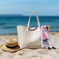 A pink cotton Scarf with a fantail bird design. Draped over a bag by the beach.