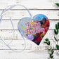 A wooden heart tag with a happy birthday message and floral design.