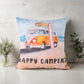 Decorative pillow with a camper van and surfboard design on a wooden surface.