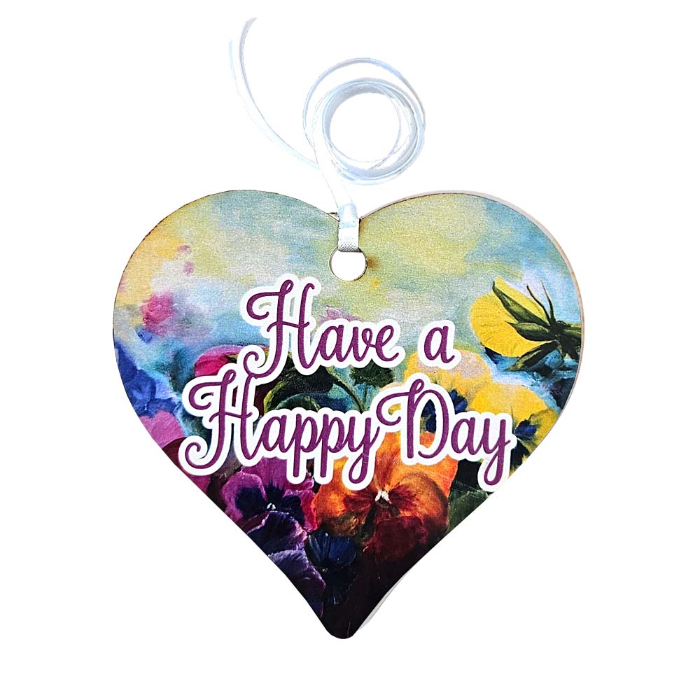 A wooden heart with have a happy day written on and a floral design.