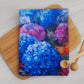 A beautiful cotton tea towel with a floral Hydrangea print. shades of blue and purple colours.