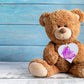 A wooden heart gift tag with a pink bunny illustration and written message of It's a Girl.