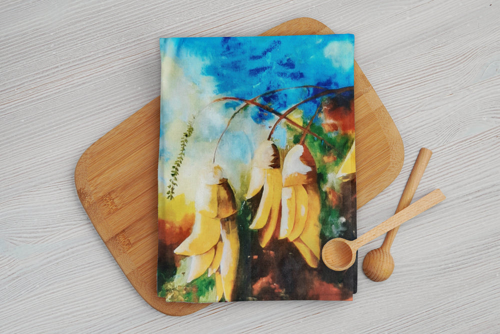 Kowhai floral print cotton tea towel with blue and yellow colours. Print taken from the original artworks of Christina Maassen Art.