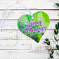 A wooden heart tag with a floral background in greens and purples with a message saying 'Loving Memories'.