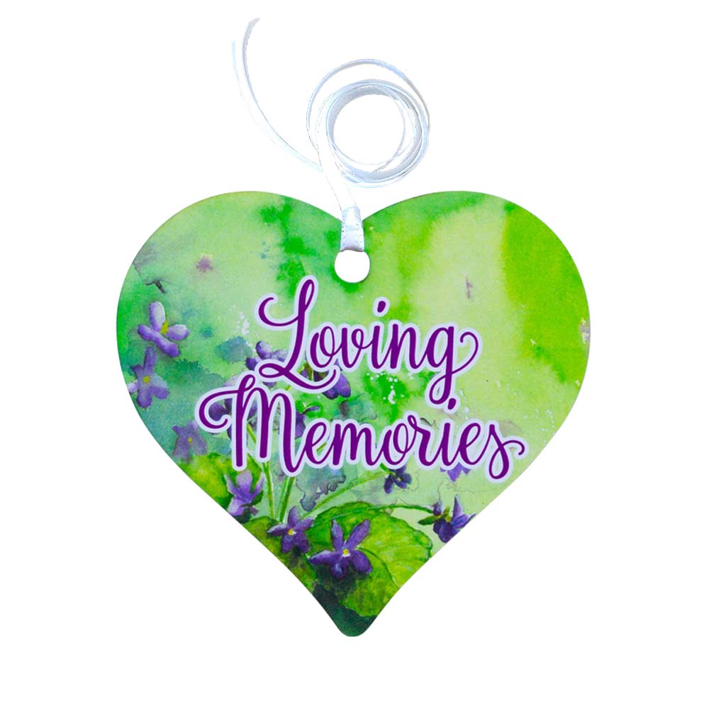 A wooden heart tag with a floral background in greens and purples with a message saying 'Loving Memories'.
