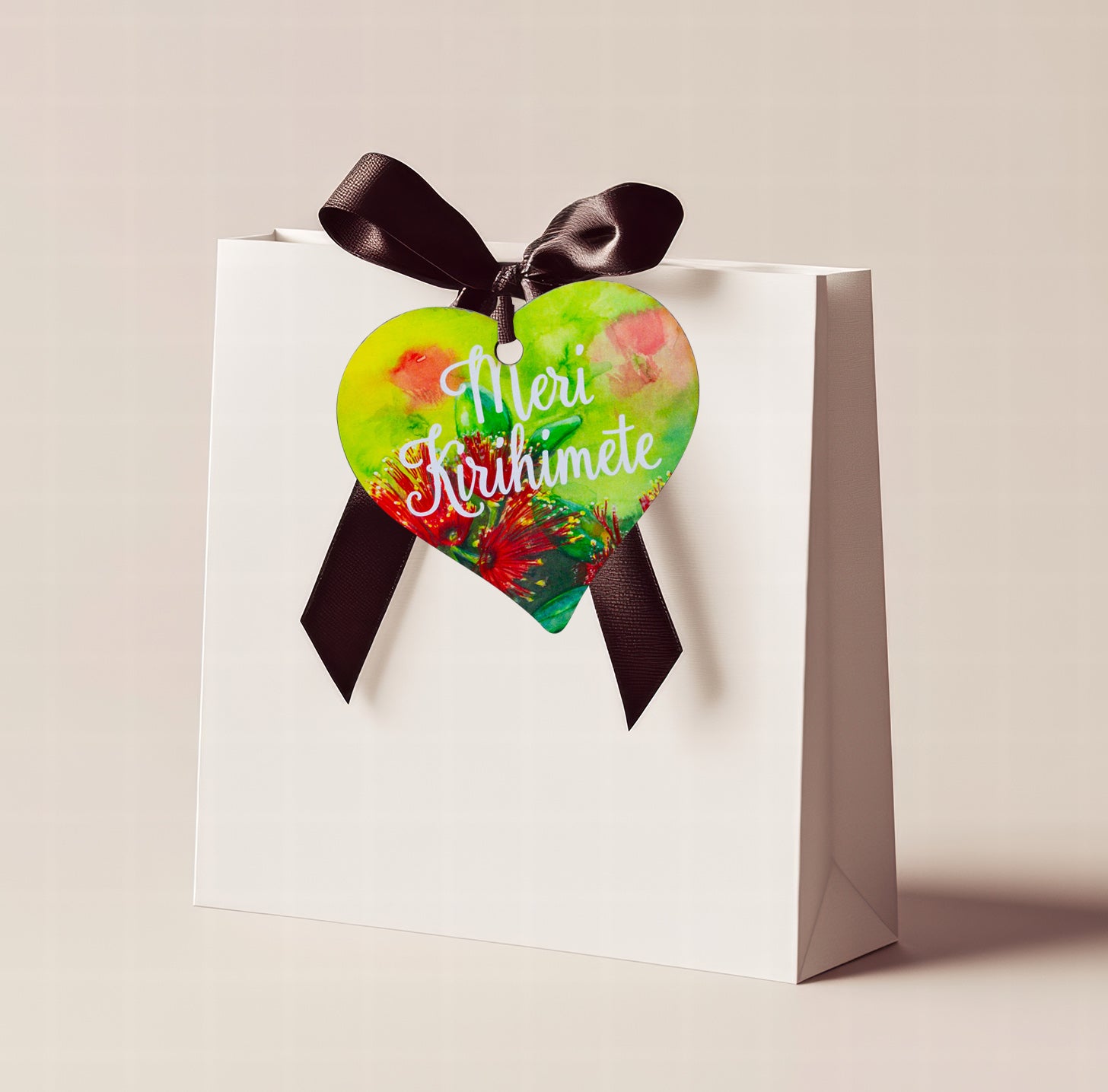 A wooden heart tag  saying Meri Kirihhimete, a kiwi christmas gift tag.