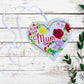 A wooden heart tag with the message 'Mum' and a floral wreath design.