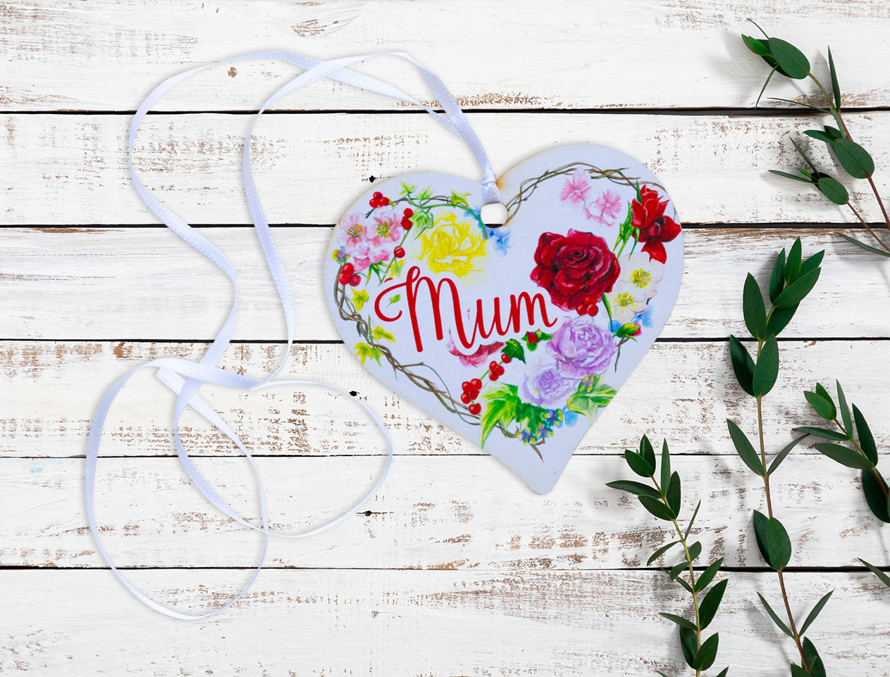 A wooden heart tag with the message 'Mum' and a floral wreath design.