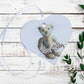 A wooden gift tag with a teddy bear illustration and the words New Baby written at the bottom. 