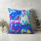 Colorful floral pillow on a wooden surface with plants