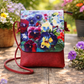 Red handbag with floral design on a wooden surface surrounded by flowers