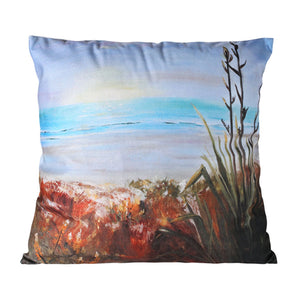 Decorative pillow with a beach scene design featuring ocean and sand.