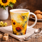 Cup with sunflower design on a wooden table with coffee and cookies.