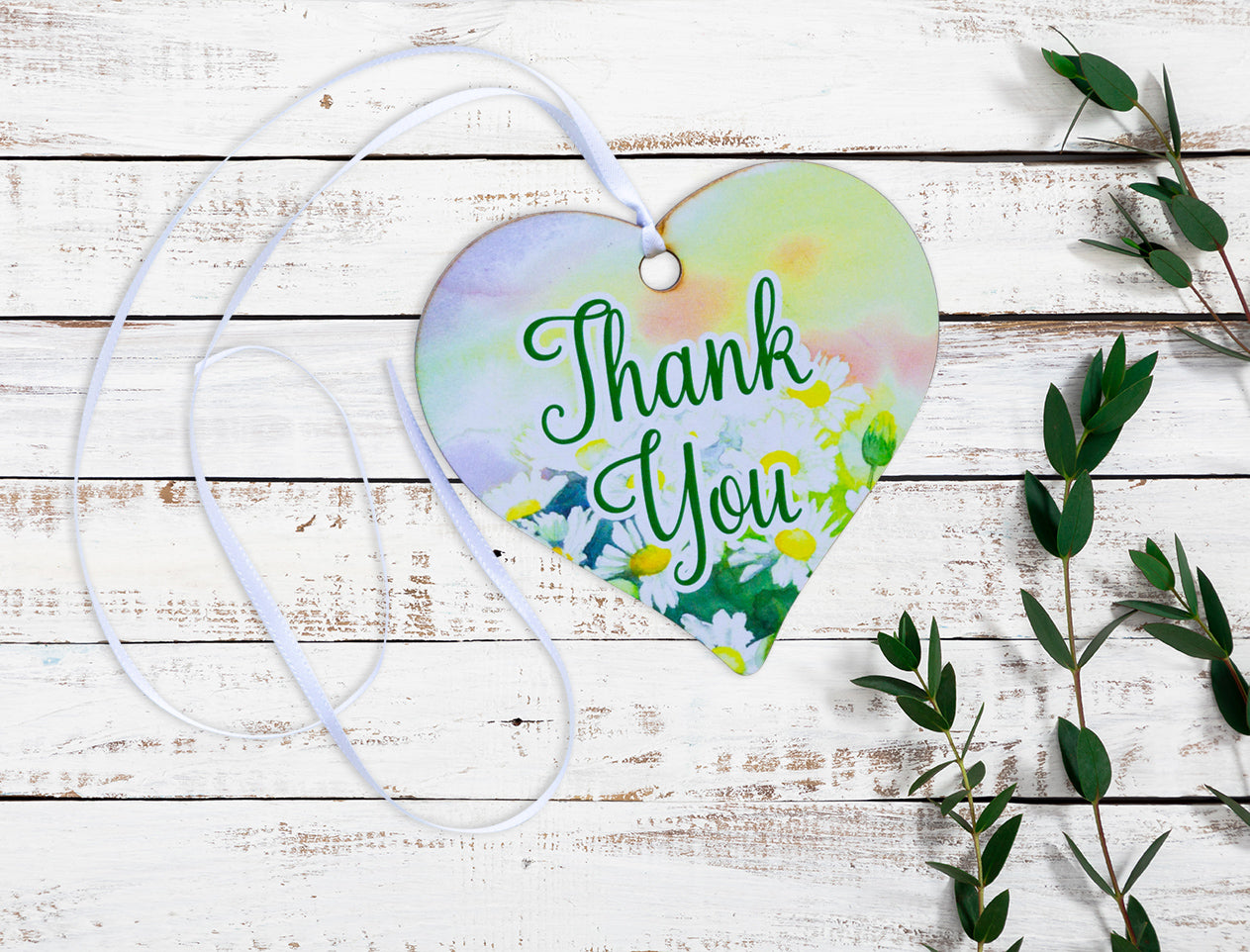 A wooden heart gift tag with a floral design taken from original artworks and the words thank you written across the front.
