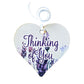 A wooden heart tag with thinking of you written, featuring  lavender flowers.